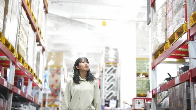 young chinese woman walking and watching in supermarket
