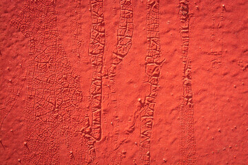 red metal plate with cracked paint and big paint spots because of time as background, metal wall with rusty spots and cracked paint as texture, toned to color, high quality resolution