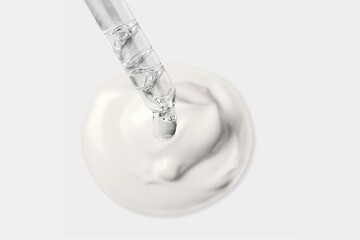 Cosmetic pipette with drops of oil, on the background of white cosmetic cream smear on the desk
