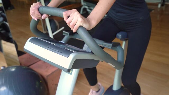 Caucasian Woman Exercise on Indoor Stationary Exercise Bike - crop shot