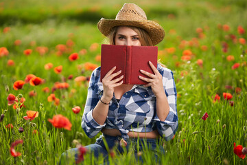 Size plus farmer lady in a poppy field reading a book