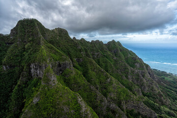 Fototapeta na wymiar Soaring mountainous peaks leading to deep valley with clouds, Oahu Island, Hawaii