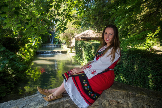 The beauty of the Bulgarian woman dressed in national costume in the sea garden of Balchik , Bulgaria.