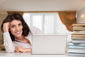 Obraz premium Cheerful laughing young woman tutor freelancer student e-learning, working remotely, watching webinar on laptop