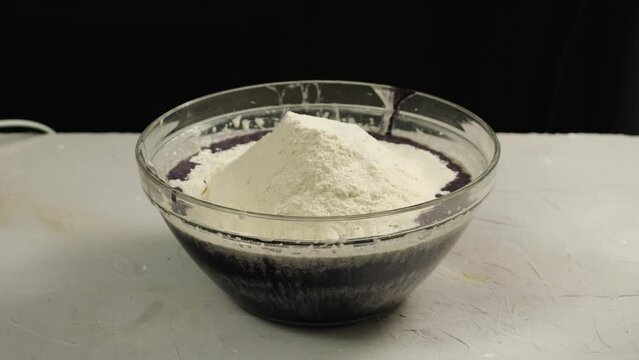 In a cup with black food coloring and flour, salt, cocoa, and vanillin are added. Concept bakery. Preparing the cake crust