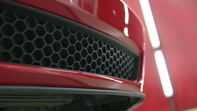 Red, luxury, sport, muscle car bumper detail. Racing automobile shiny hull pan.