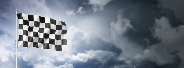 Auto racing finish checkered flag on a cloudy sky