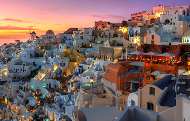 Oia town on Santorini island, Greece. Traditional and famous houses and churches with blue domes over the Caldera, Aegean sea