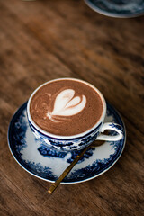 Hot chocolate with heart shape on the table brown wood.