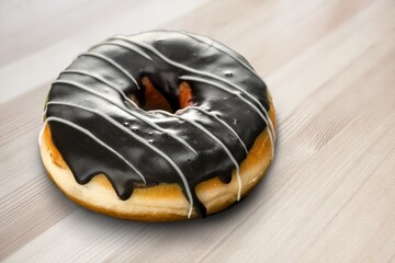 Tasty sweet chocolate glazed donut with crumbs and creme filled