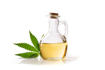 Yellow hemp oil in a bottle with a wooden stopper with a green leaf of the cannabis plant.
