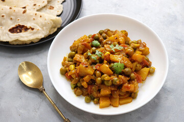 Aloo Matar curry. Potato, Peas cooked with an Onion and Tomatoes along with Indian spices. Garnished with coriander leaves. Served with chapati or bhakri. Copy space