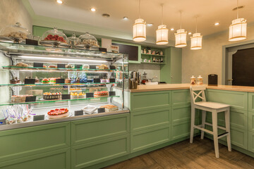 Cafe interior with counter and showcase offering natural zefir and cakes for sale