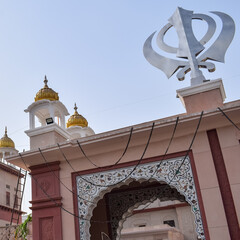 Khanda Sikh holy religious symbol at gurudwara entrance with bright blue sky image is taken at Sis...