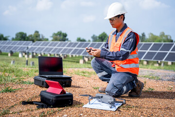 Engineers preparing drones to fly, inspecting the solar cells at high angles to thermo scan the...