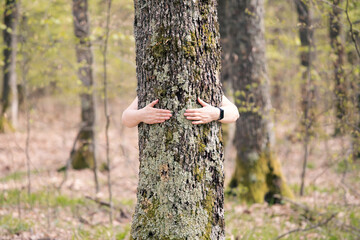 People embracing nature, with a hug at a tree