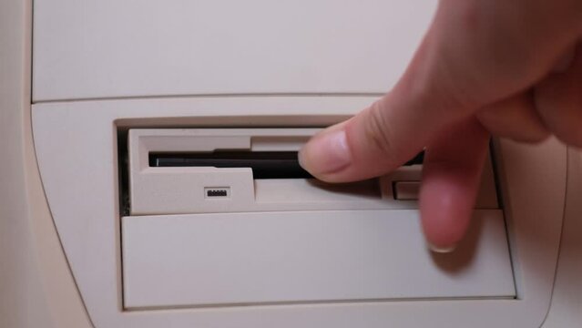 Close-up of installing floppy disk in retro computer. Diskette scan. Retro computer