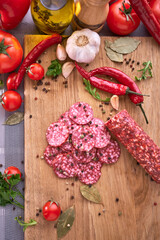 Sliced salami sausage on wooden cutting board at domestic kitchen