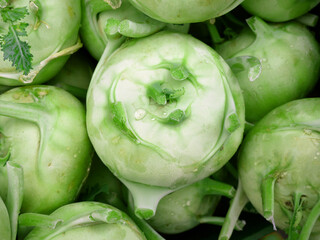 Young sweet kohlrabi at the spring market. Root without leaves. Close up. Full frame composition....