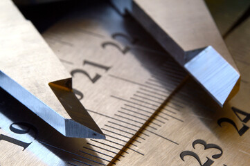Accurate measuring tool caliper and metal ruler lie on top of each other. close-up.