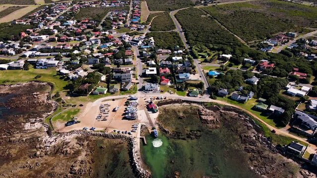 Aerial tilt-down over harbour as shark cage diving boat is pulled up slipway