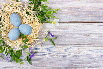 Easter background. Easter eggs on a light wooden table. View from above.