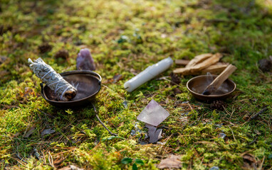 occult science and supernatural concept - close up of white sage in cup and stuff for magic ritual in forest
