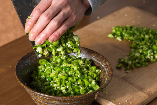 Chef kitchen knife on hangzhou green chili into bowls only hands no face