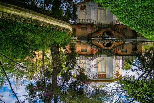 "The Little Casino" in the historic open public garden "El Capricho", formerly belonging to the Dukes of Osuna.
The photograph is inverted, leaving the reflection above and the real below