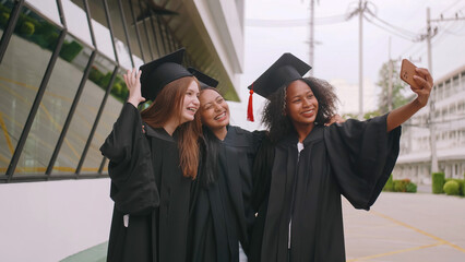 Group of friends having fun celebrating their graduation by taking pictures together.