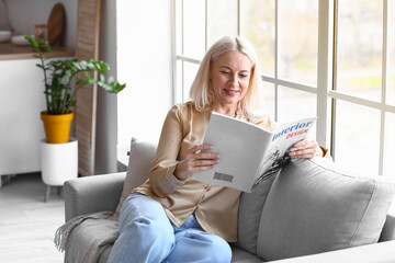 Morning of beautiful mature woman reading magazine at home