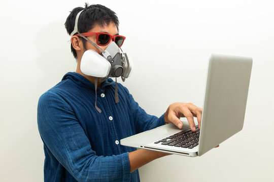 Man protection cartridge respirator gas mask  using laptop.