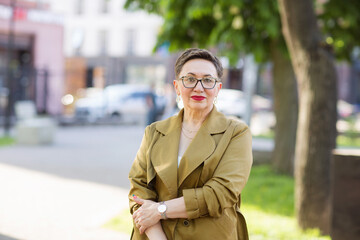portrait of a stylish serious middle-aged woman on street of city of outdoor. - obrazy, fototapety, plakaty