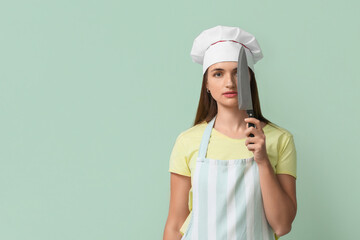 Female chef with kitchen knife on green background