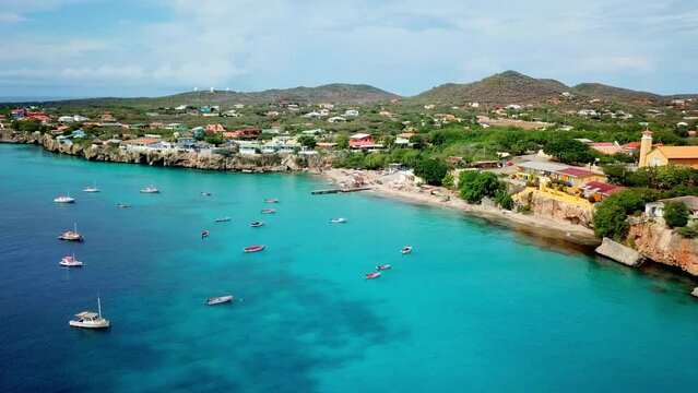 Aerial orbit of Forti Beach in Westpunt, Dutch island of Curacao, Caribbean Sea. Fishing boats on the shore.