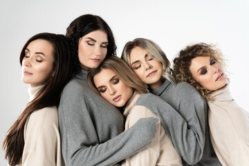 Group of different women wearing turtleneck jumpers on gray background