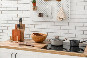 Cutting boards with knife and bowls on counter near white brick wall