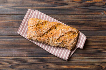 Fresh loaves of bread with wheat and gluten on a colored table. bread on napkin on rustic background, fresh bread top view