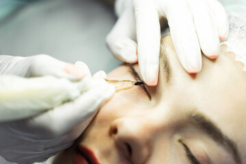 Obraz na płótnie Canvas Young woman during professional permanent makeup treatment