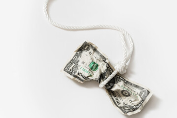 White rope tangled around a crumpled one dollar bill.