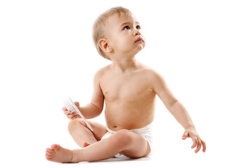 Little boy in diaper sitting and playing with brush.