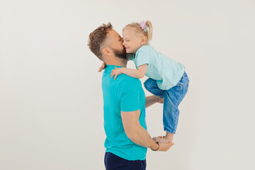 Portrait of athletic man with pumped up arms holding and lifting up with hands smiling little girl,...