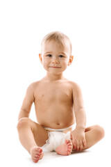 Curious healthy little boy in diaper sitting and smiling.