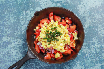 ready to fry chopped onions, tomatoes chilies, egg and barbequed brinjal