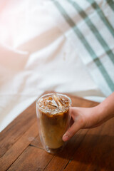 Ice coffee on a black table with cream being poured into it showing the texture and refreshing look of the drink