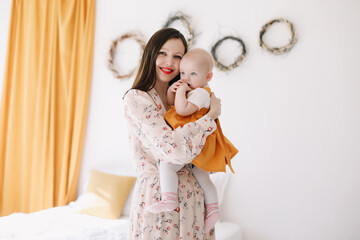 Happy mom holding and hugging little daughter, loving family sincere feelings. Mother and baby
