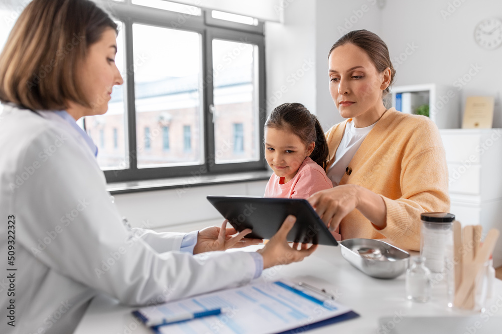 Sticker medicine, healthcare and pediatry concept - mother with little daughter and doctor showing tablet pc computer at clinic