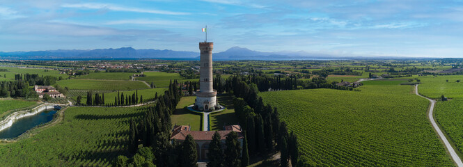 Aerial panorama of Tower of San Martino della Battaglia, Italy. Tower surrounded by vineyards drone...