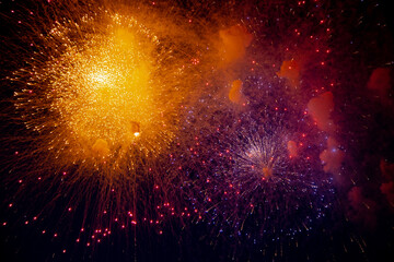 Bright orange and blue fireworks on the background of the night sky. High quality photo