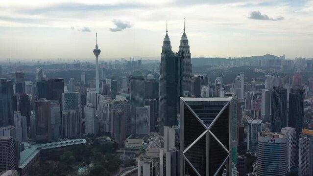 Establishing shot fly around downtown kuala lumpur capturing populous cityscape with futuristic skyscrapers, high rise building and twin towers and kl tower in the scene, fast development in asia.